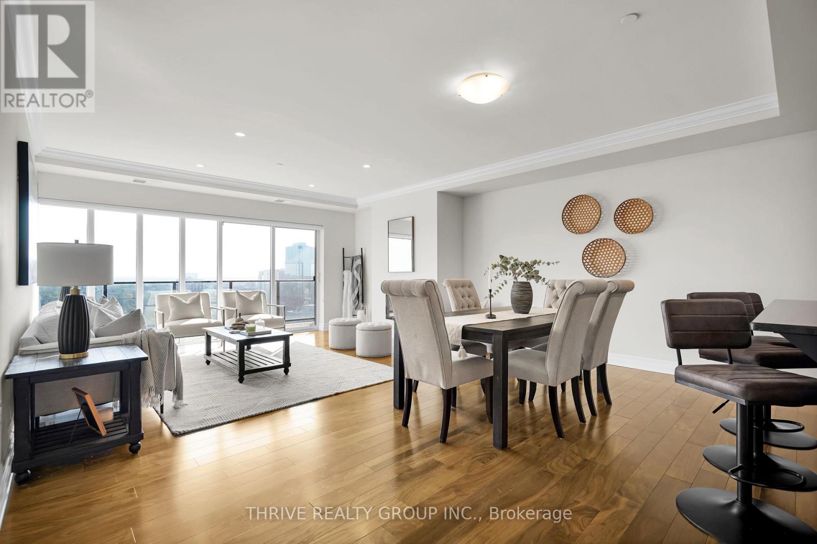 A modern living room with a dining area and a view of the city.