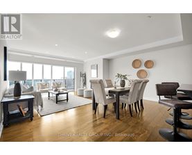 A modern living room with a dining area and a view of the city.