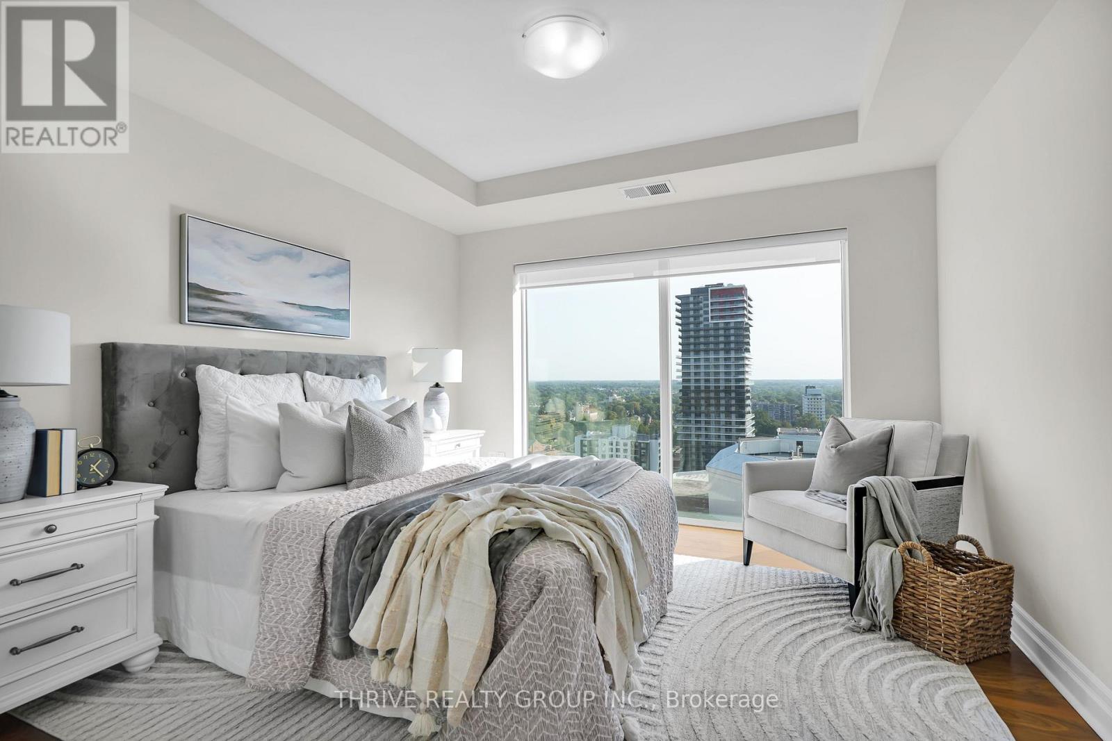 A bedroom with a large bed and a view of the city.