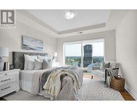 A bedroom with a large bed and a view of the city.