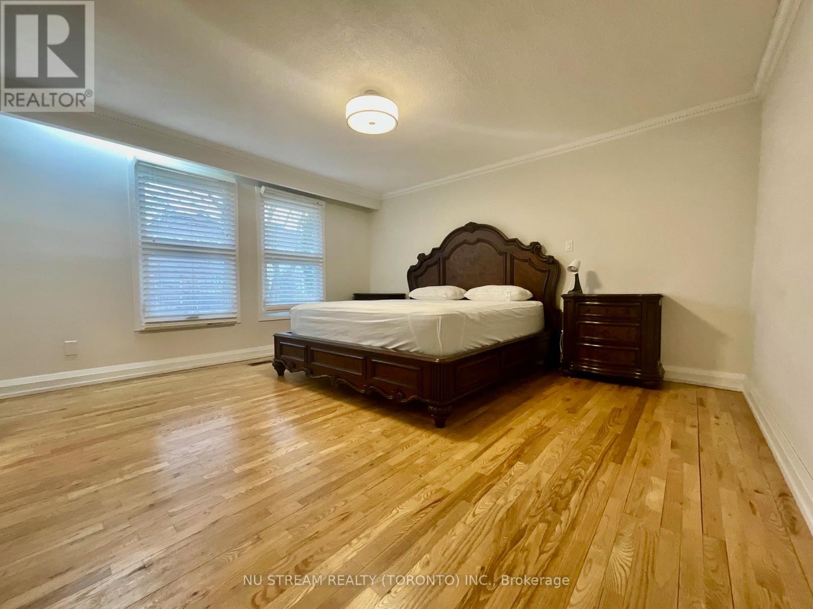 A bedroom with a bed, dresser, and window.