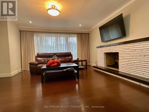 A living room with a brown leather couch and a flat screen TV mounted on the wall.