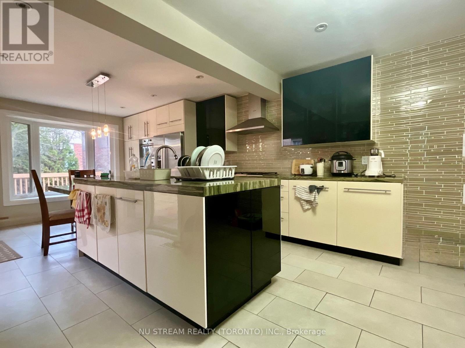 A modern kitchen with white cabinets and a black countertop.