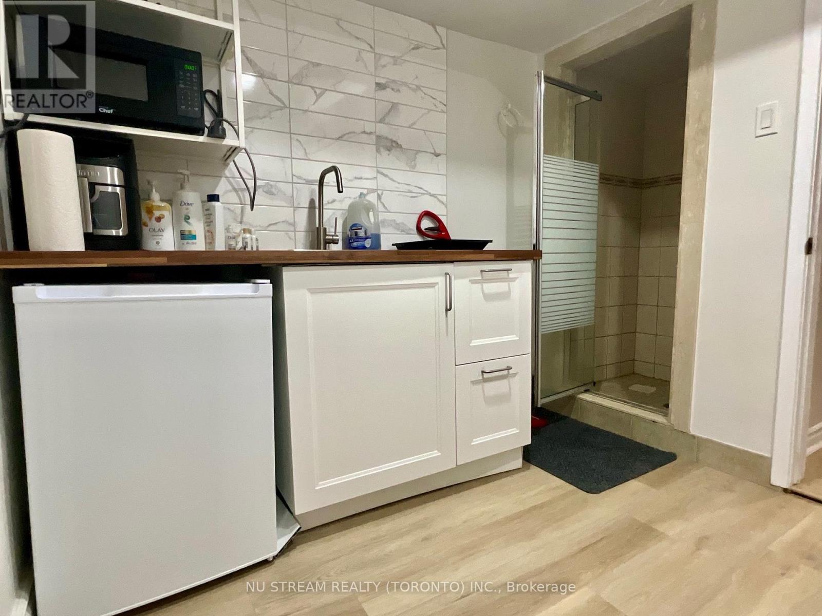 A kitchen with white appliances and a wooden counter.