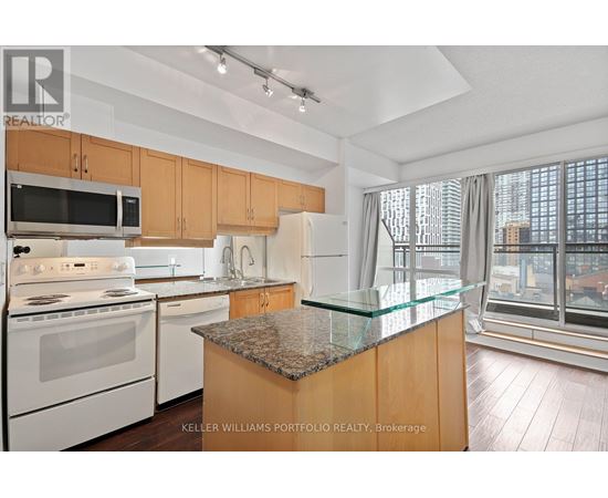 A kitchen with a granite counter top and a view of the city.