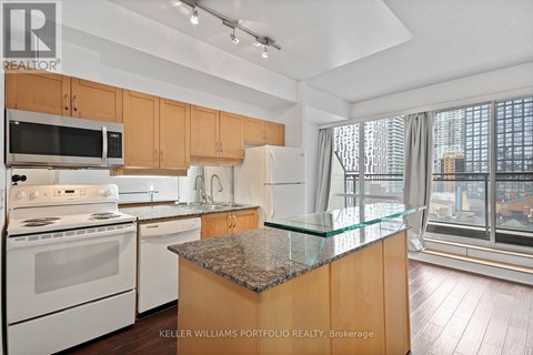 A kitchen with a granite counter top and a view of the city.