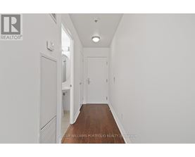 A long hallway with white walls and wood floors.