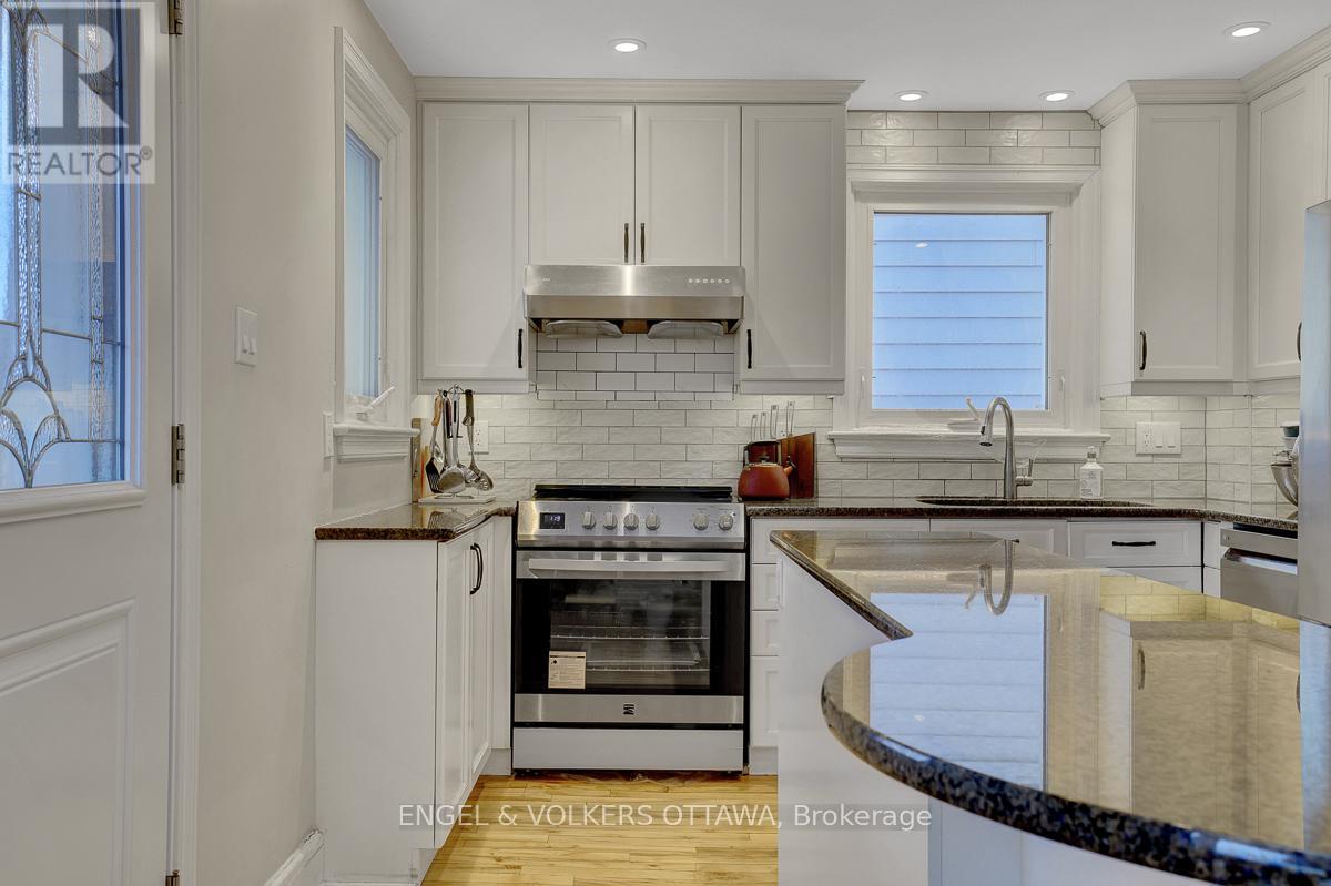 A modern kitchen with a stainless steel oven and white cabinets.