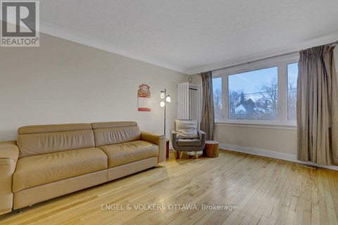 A living room with a tan couch and a grey armchair.