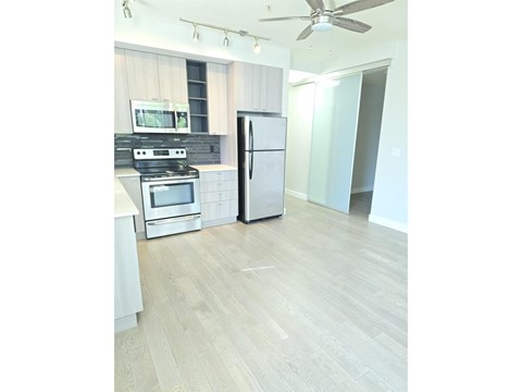 A kitchen with a refrigerator, oven, and microwave.