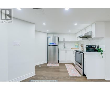 A kitchen with white cabinets and a stainless steel refrigerator.
