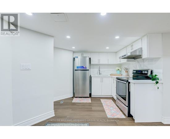 A kitchen with white cabinets and a stainless steel refrigerator.