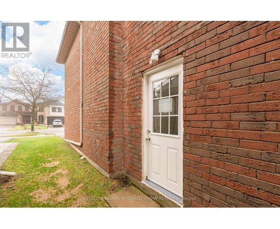 A white door is on a brick wall.