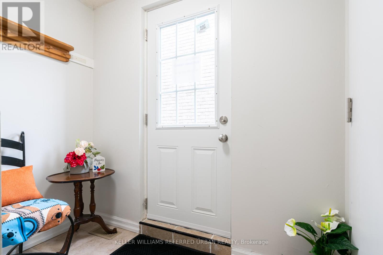 A small room with a white door and a table with flowers on it.