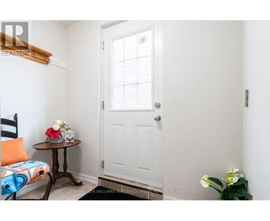 A small room with a white door and a table with flowers on it.