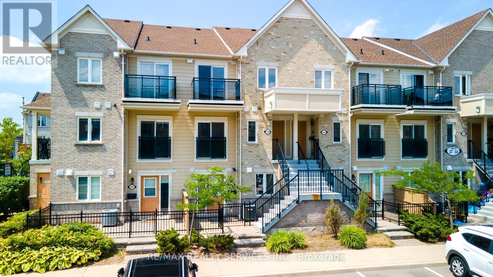 A large, multi-story residential building with balconies and a car parked in front.