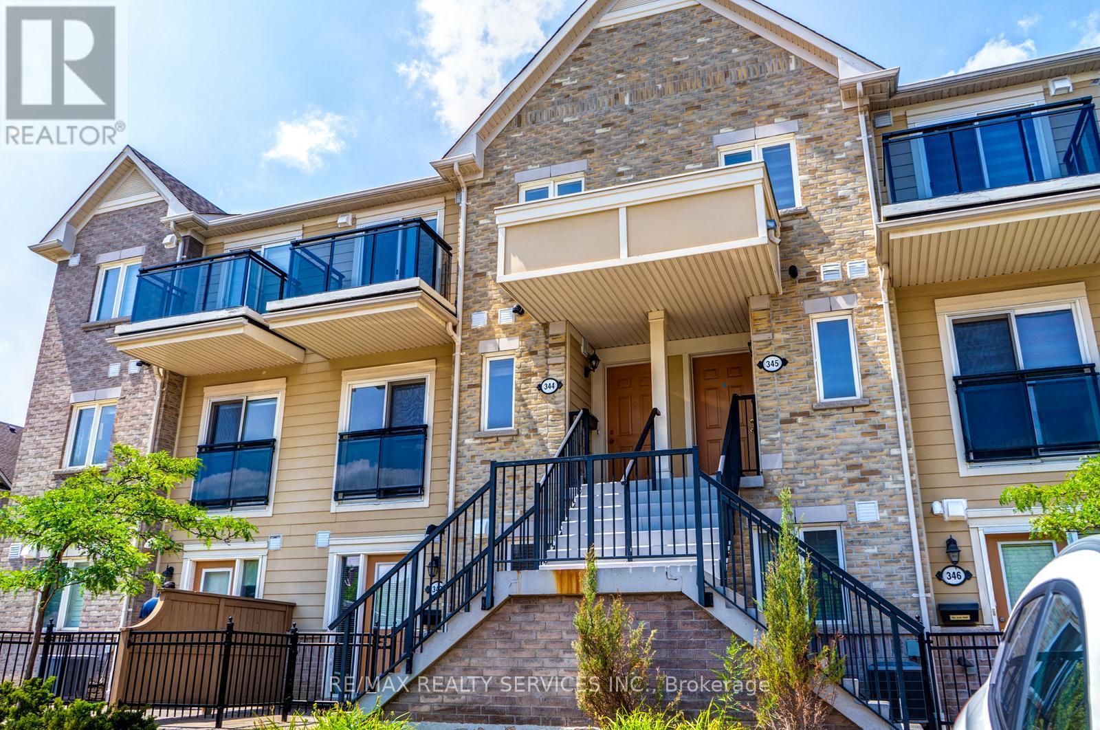 A large two-story house with a balcony and a stone facade.