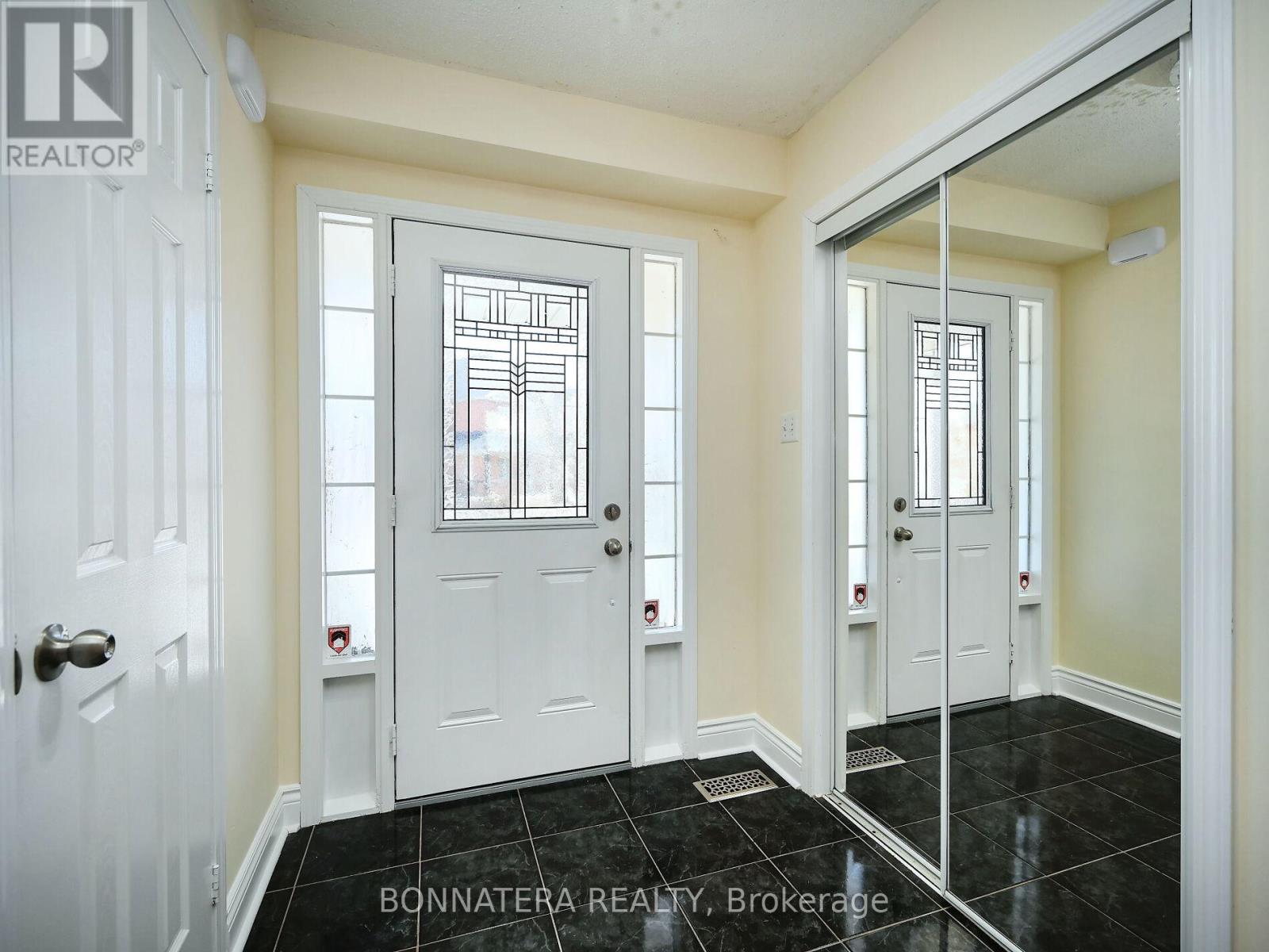 A hallway with white doors and a black floor.