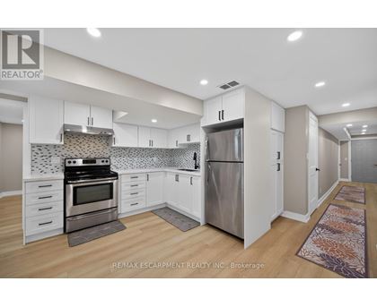 A kitchen with white cabinets and a tile backsplash.