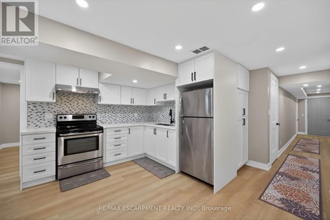 A kitchen with white cabinets and a tile backsplash.