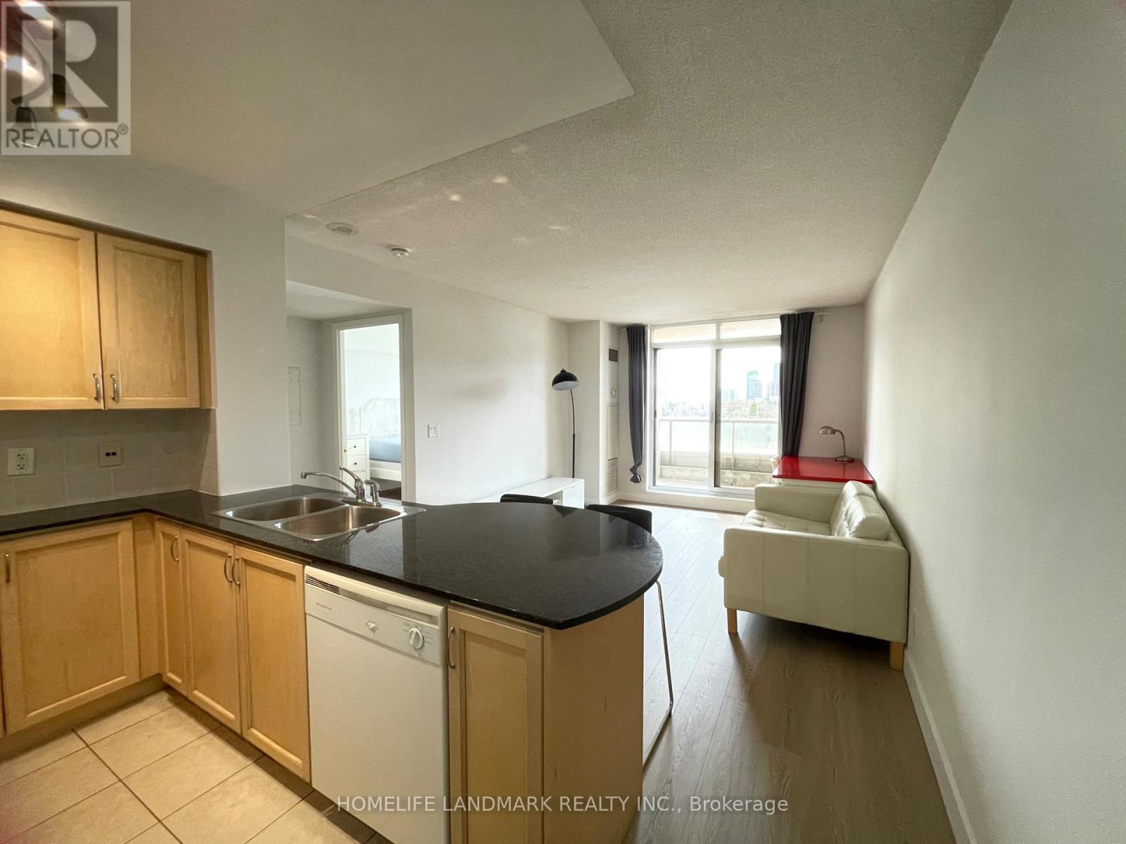 A kitchen with wooden cabinets and a black countertop.