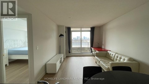 A living room with a white couch and a large window.