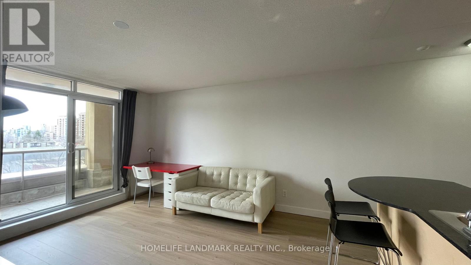 A living room with a white couch and a red table.