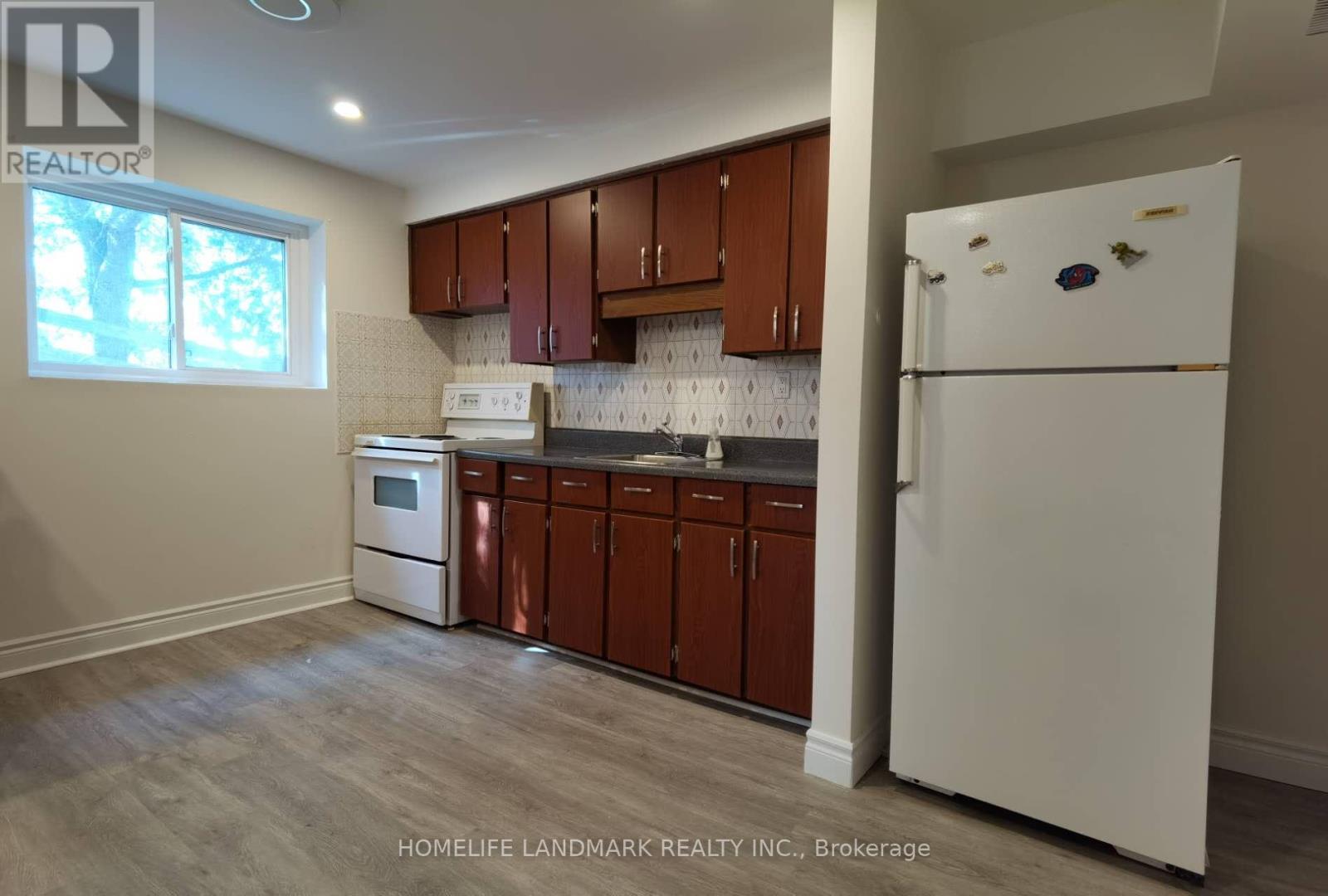 A kitchen with brown cabinets and a white fridge.