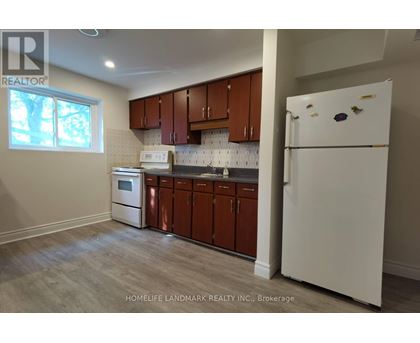 A kitchen with brown cabinets and a white fridge.