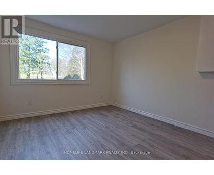 A room with a window and a wooden floor.