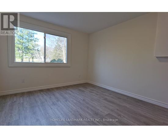 A room with a window and a wooden floor.