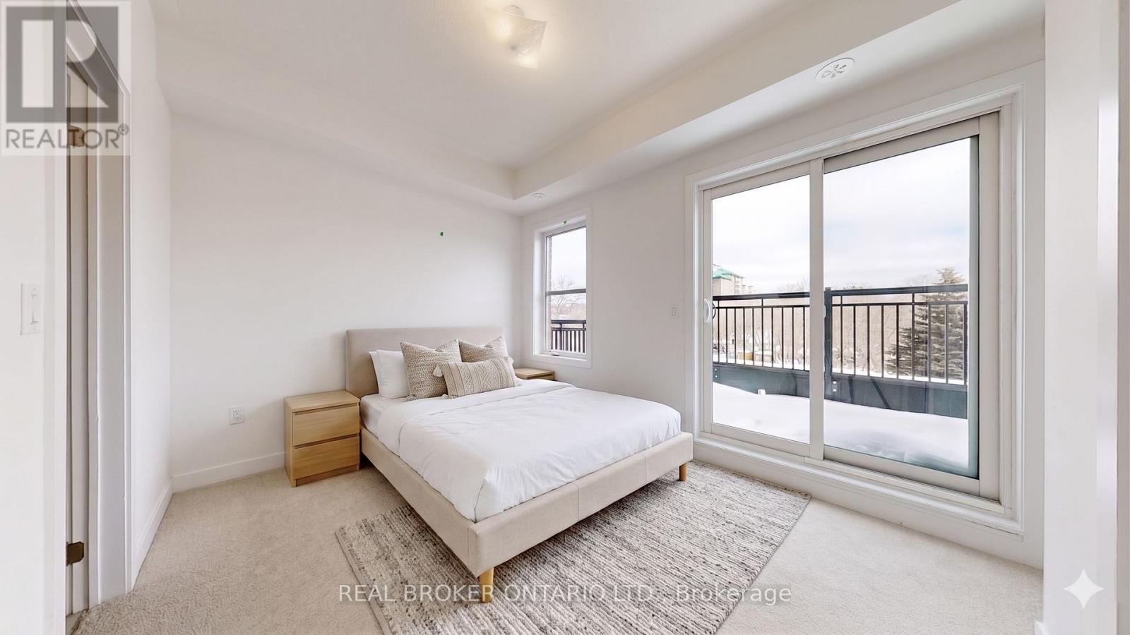 A bedroom with a large bed and a view of a balcony.