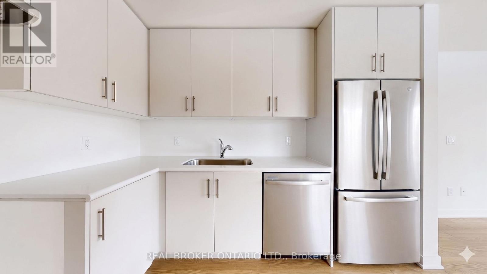A kitchen with white cabinets and a white fridge.