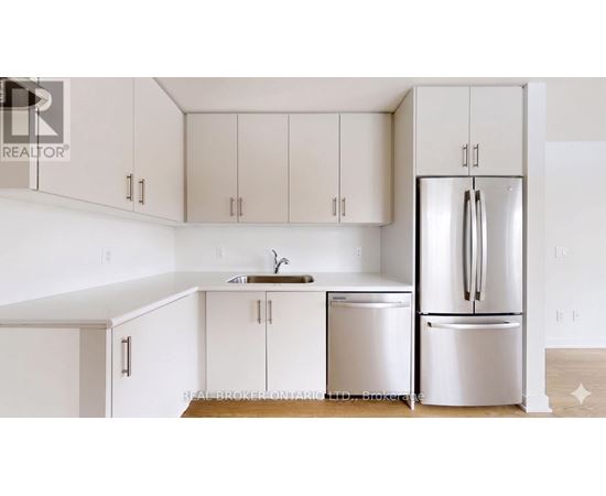 A kitchen with white cabinets and a white fridge.