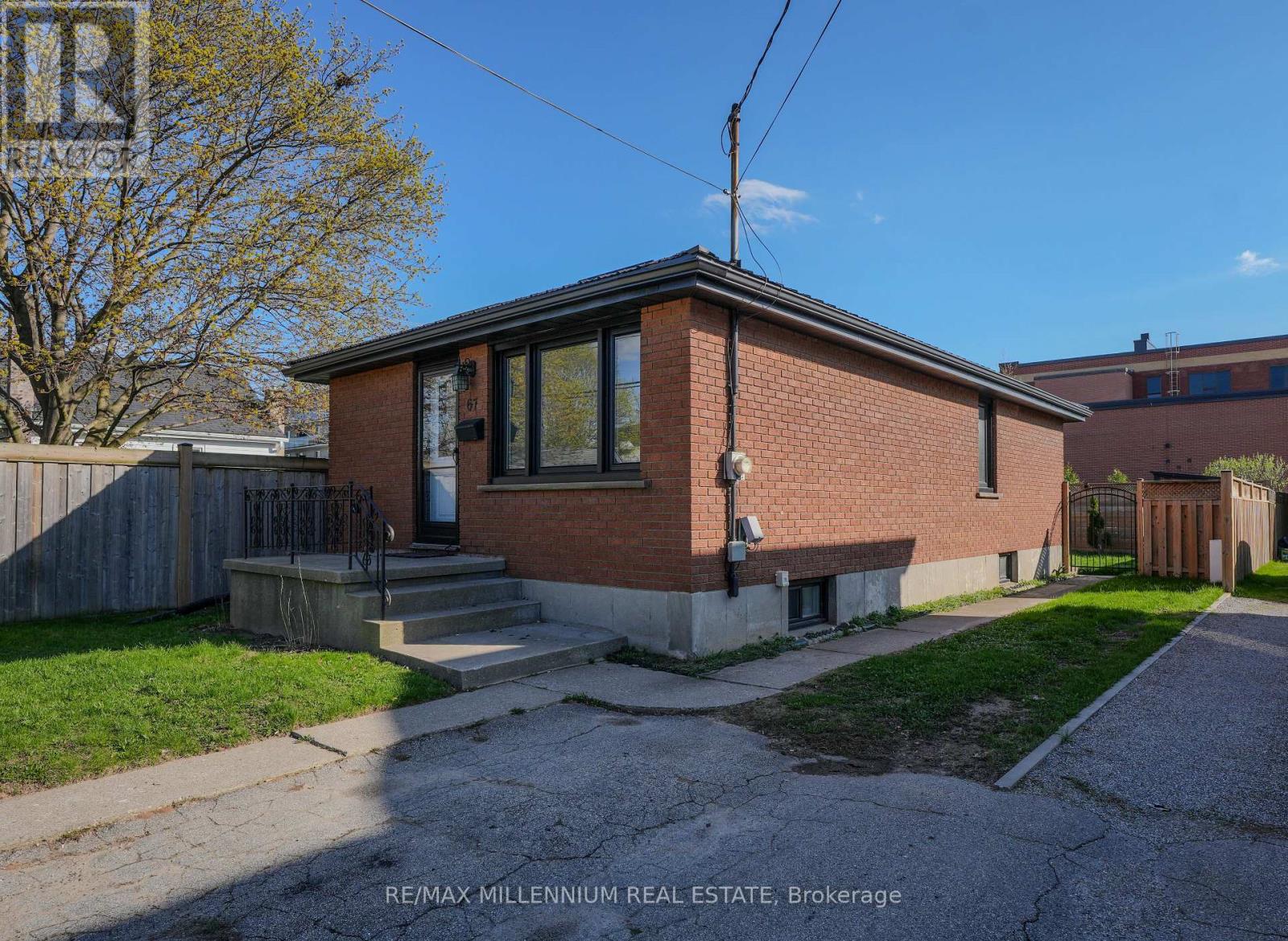 A small brick house with a front porch and a driveway.