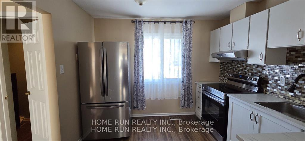 A kitchen with a refrigerator and cabinets.