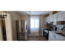 A kitchen with a refrigerator and cabinets.