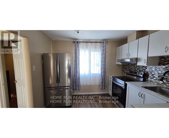 A kitchen with a refrigerator and cabinets.