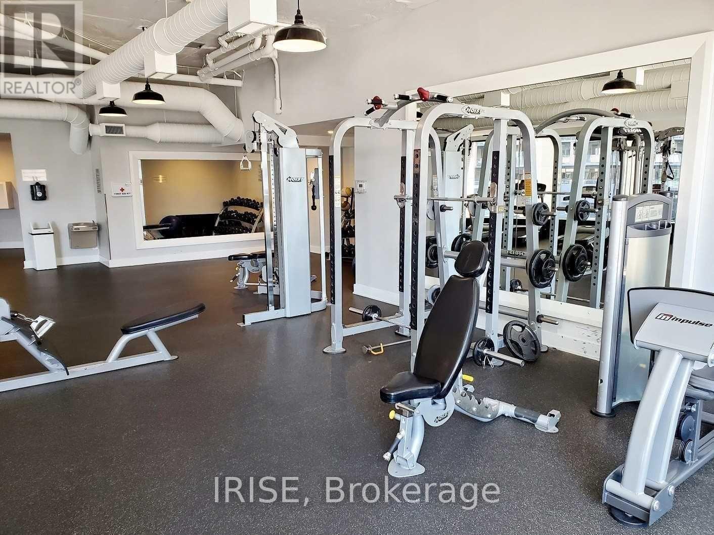 A gym with a variety of equipment including a squat rack, a leg press machine, and a bench.