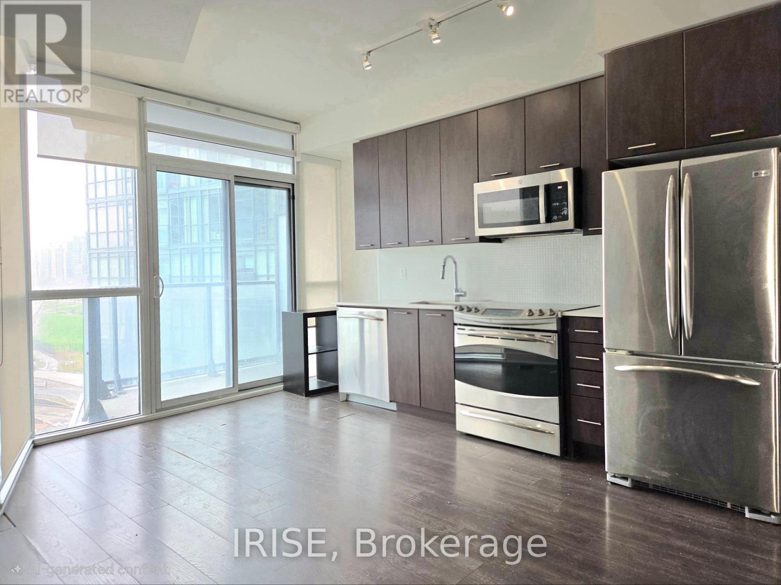 A kitchen with a refrigerator, microwave, oven, and sink.