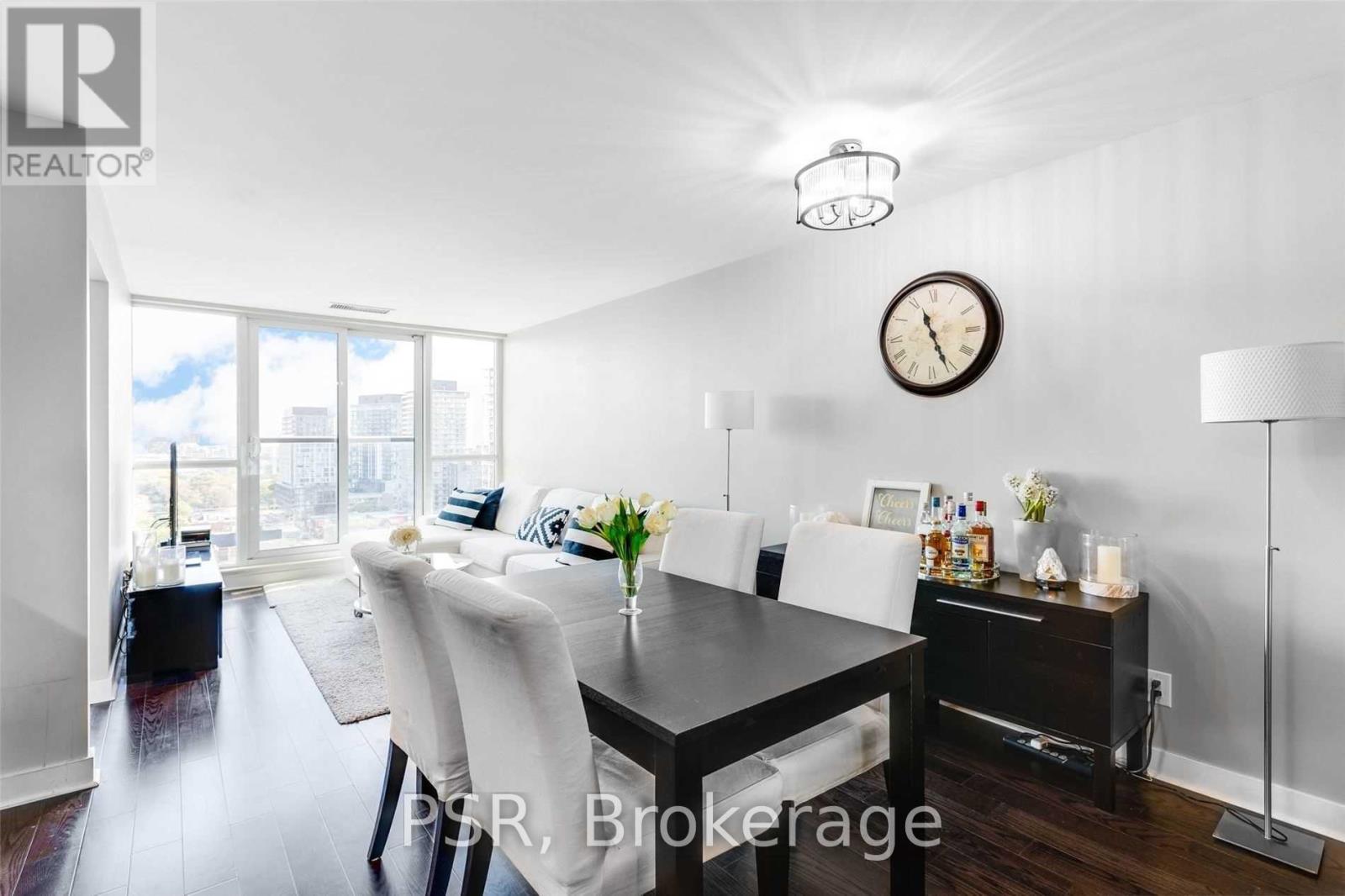 A dining room with a table set for four and a large window.