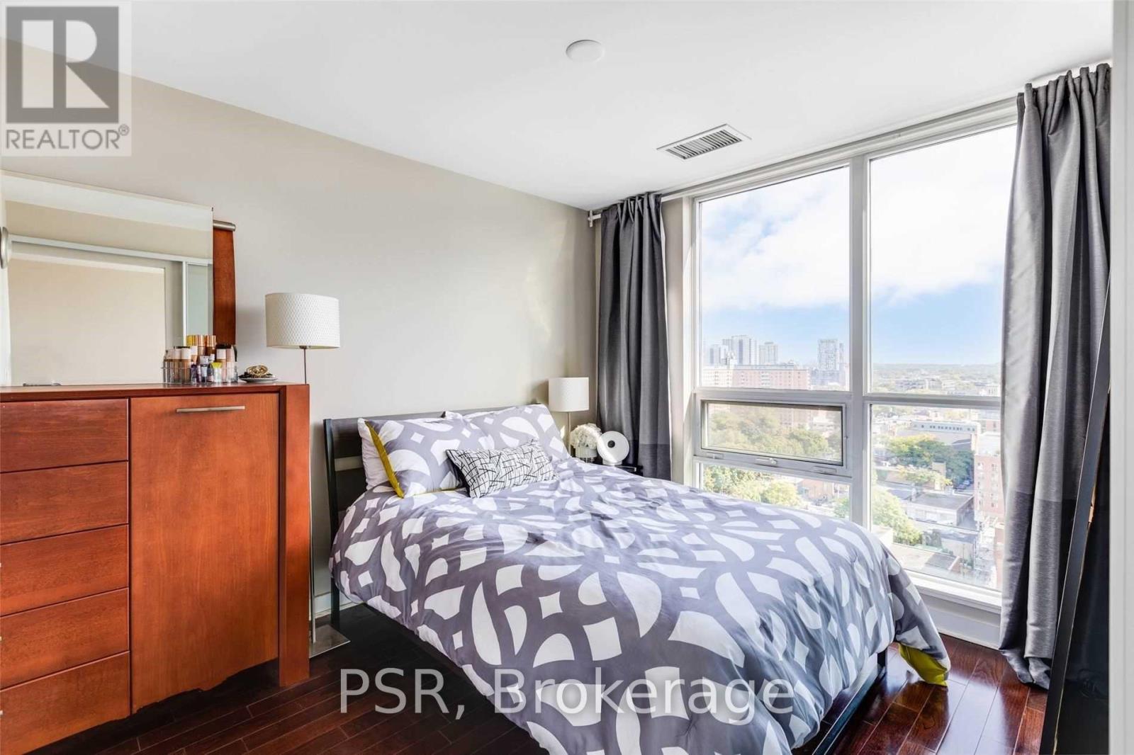 A bedroom with a large bed and a view of the city.