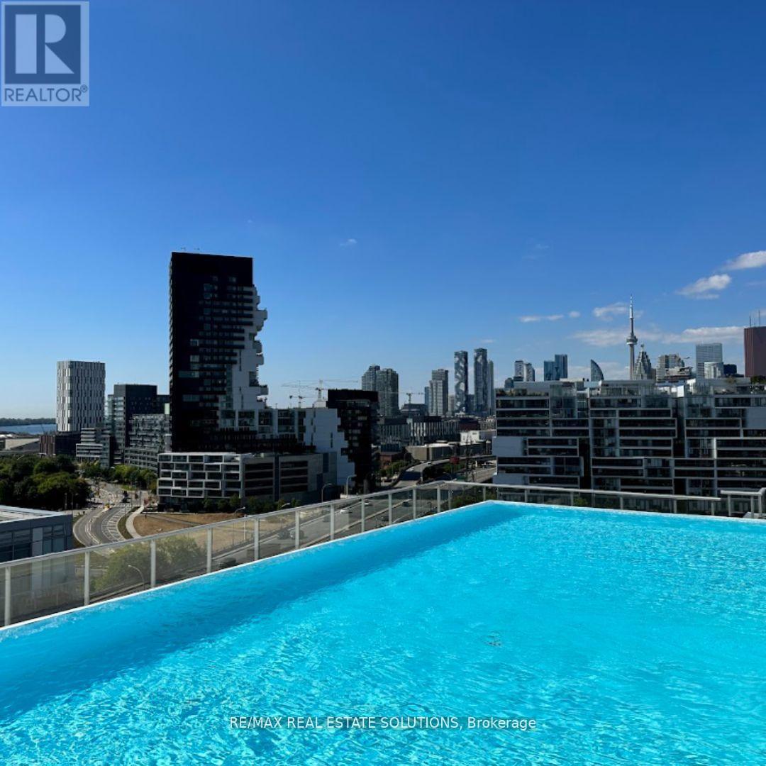 A swimming pool on a balcony with a city skyline in the background.