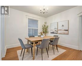 A dining room with a wooden table and grey chairs.