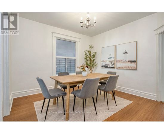 A dining room with a wooden table and grey chairs.