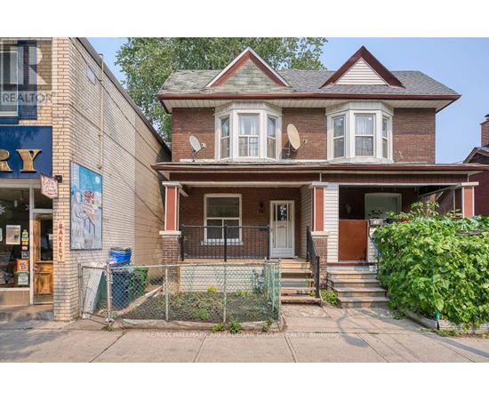 A house with a brown roof and a white door is in front of a building with a sign that says "REALTOR".