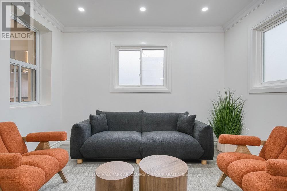 A living room with a grey couch, orange chairs, and a wooden coffee table.