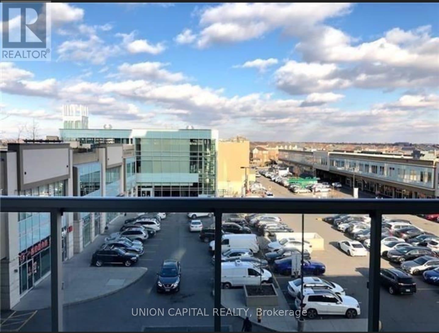 A parking lot with cars and a building in the background.