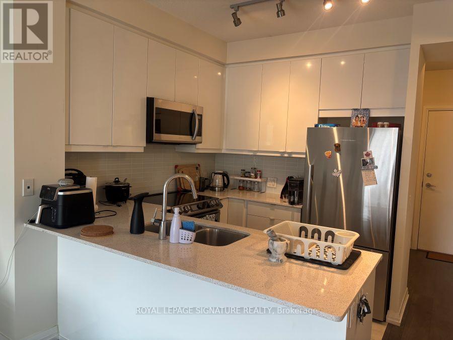 A kitchen with white cabinets and a granite countertop.