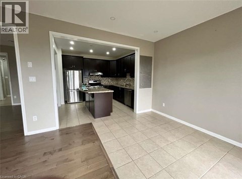 A kitchen area with a countertop and cabinets is visible through an open doorway.